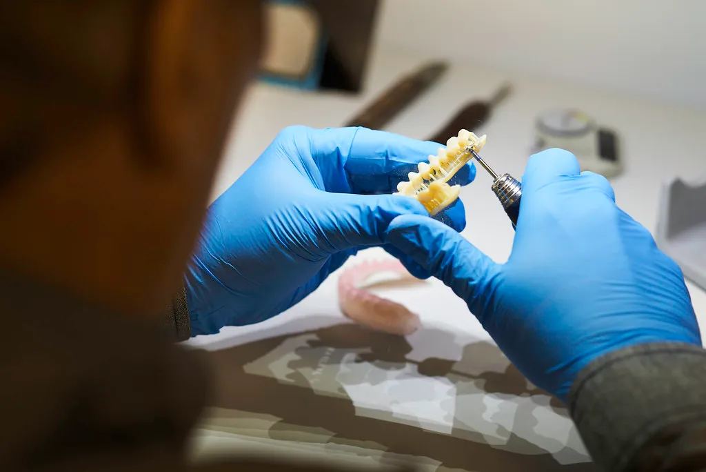 Technician assembling an implant-supported restoration on a 3D-printed model